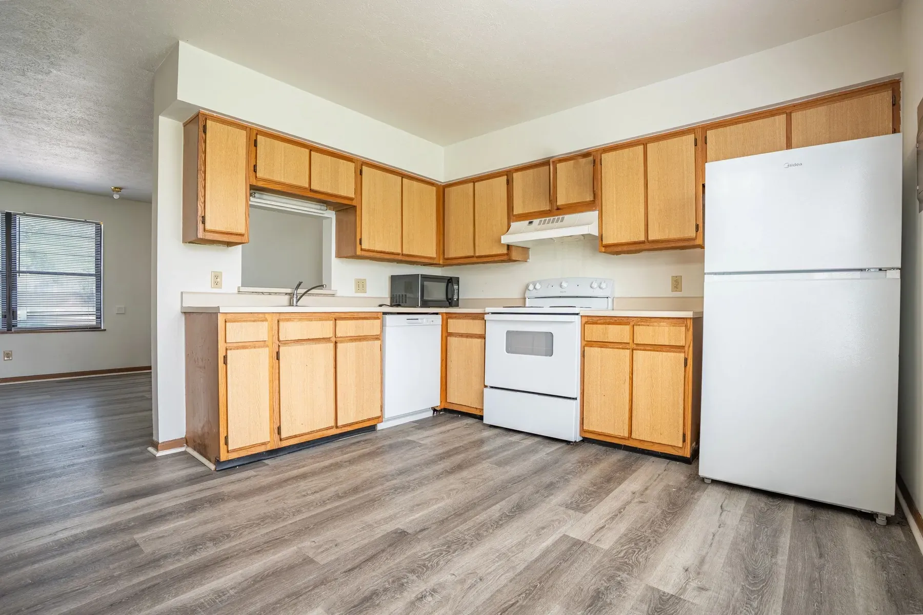 Kitchen with wood cabinets and white appliances