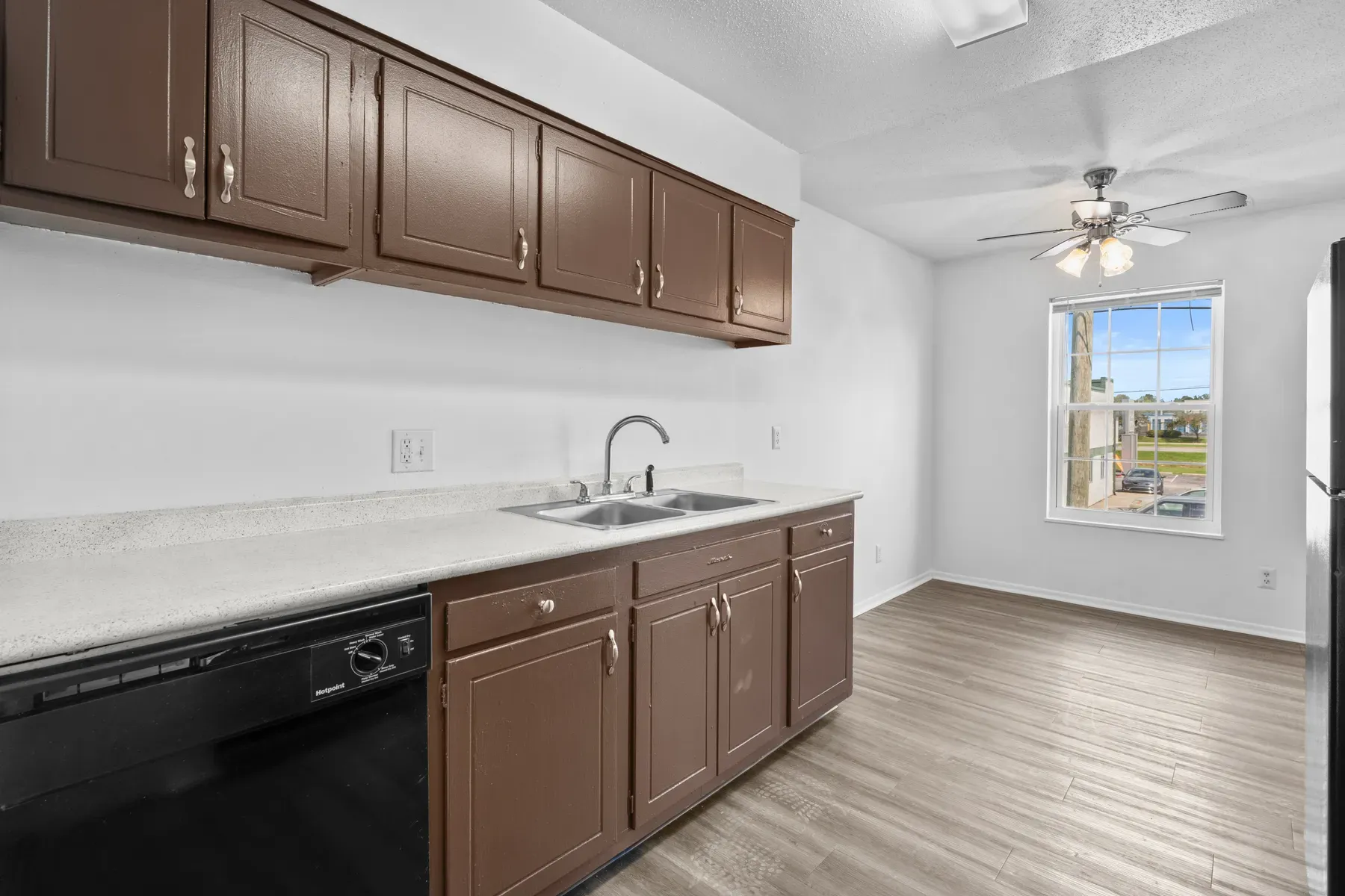 Kitchen with a dishwasher, double sink and light countertops