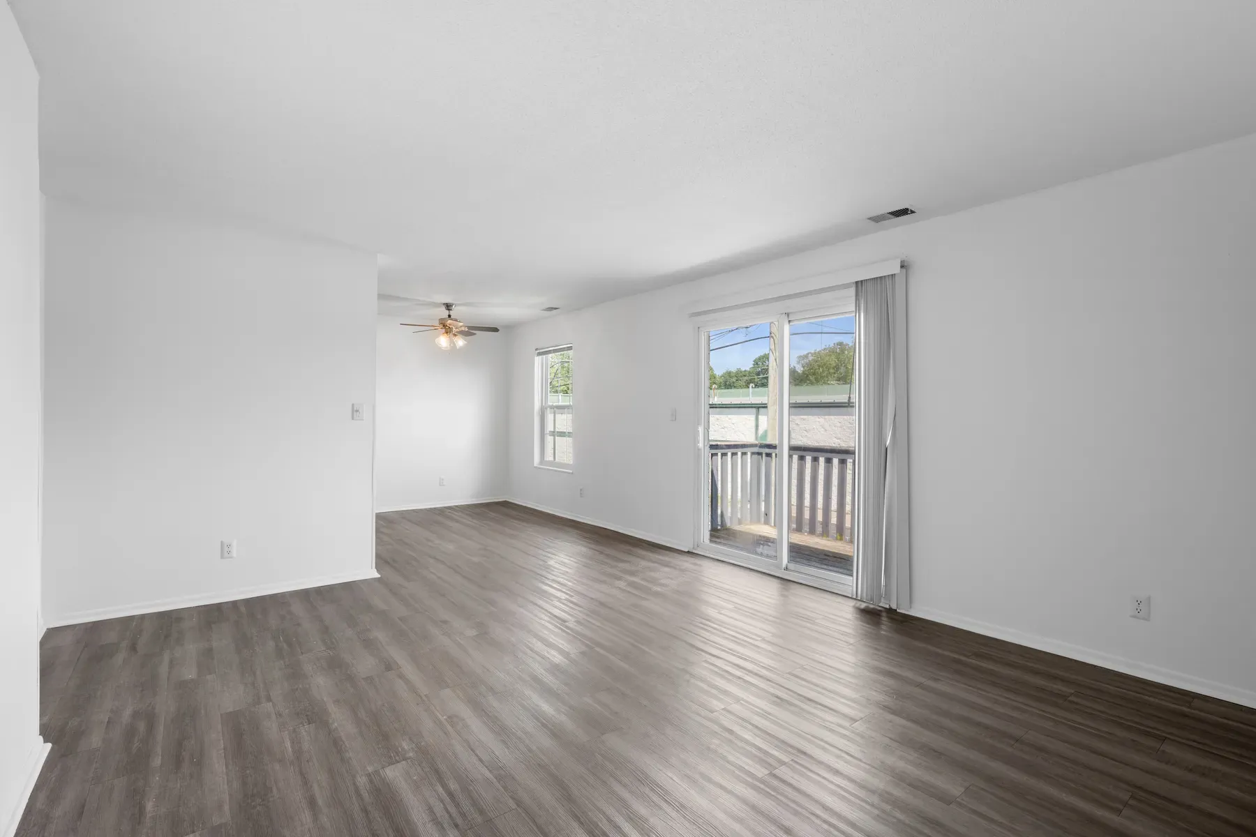 Open living and dining area with wood-look flooring