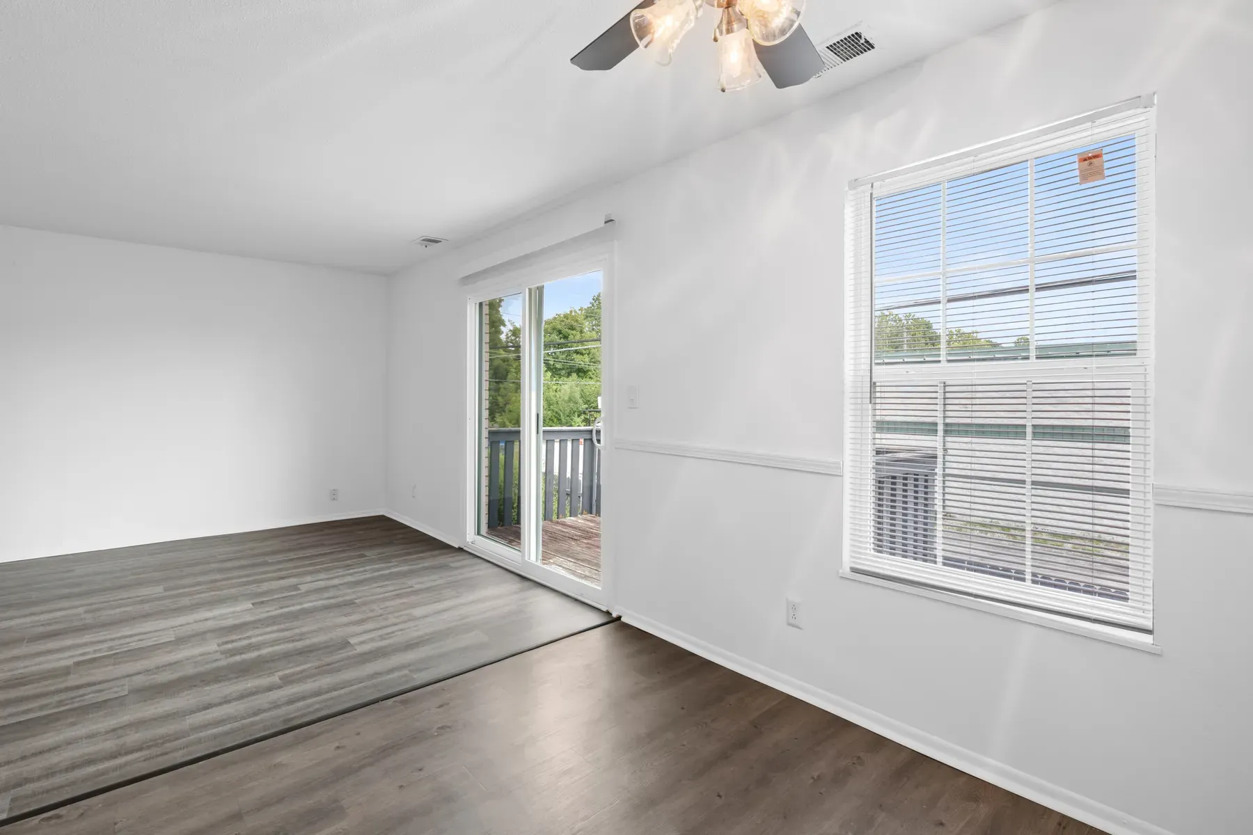 Sunlit living room with neutral walls and wide-plank floors