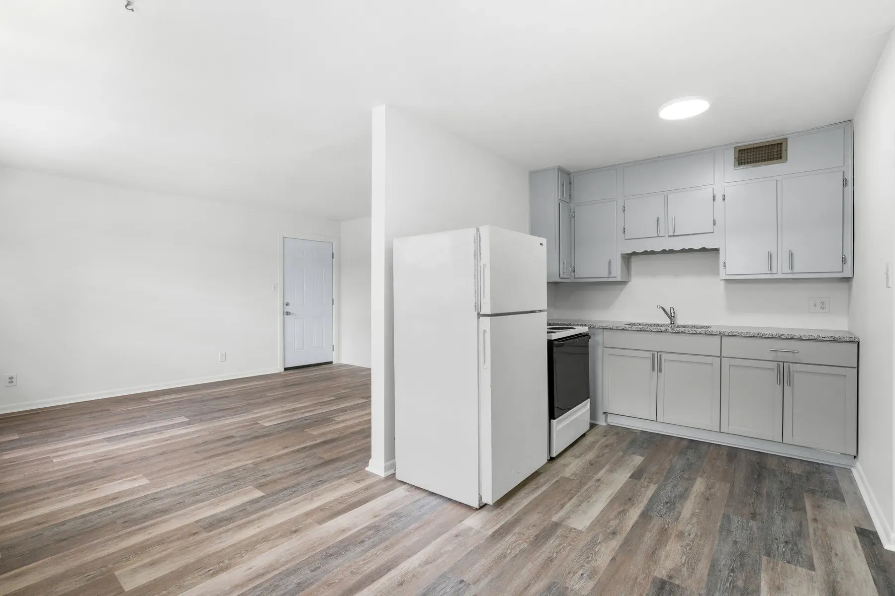 Kitchen with a white range and refrigerator and gray shaker cabinets