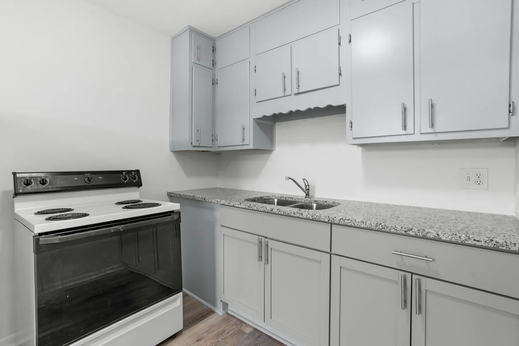 Kitchen with light stone-look counters and gray cabinets