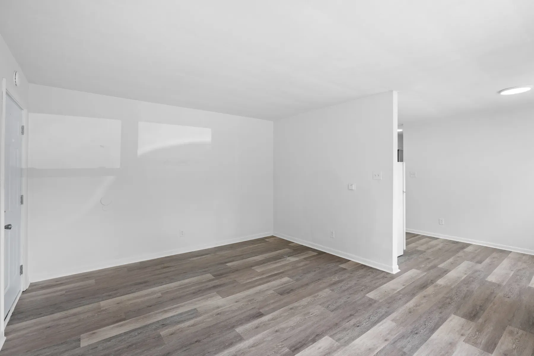 Bright living room with a large window and wide-plank floors