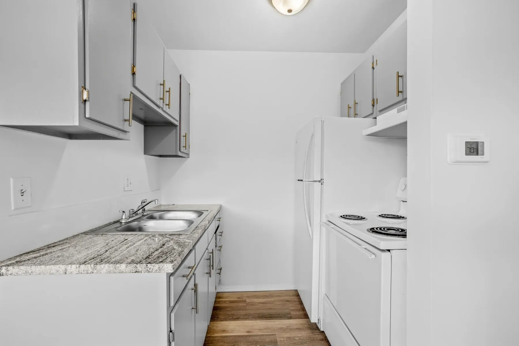 Kitchen with a white range, sink and light countertops