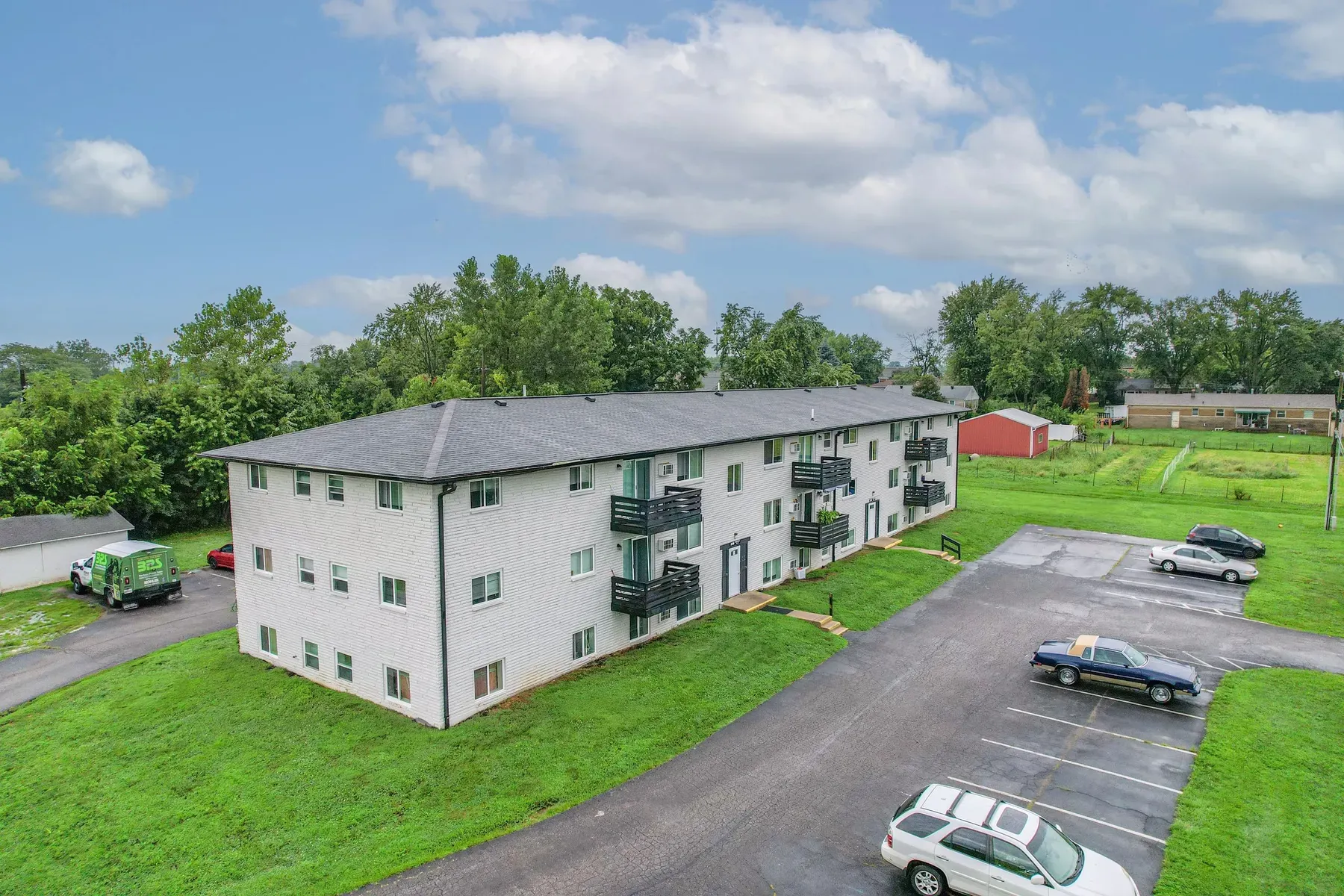 Aerial view of a three-story apartment building and lawn